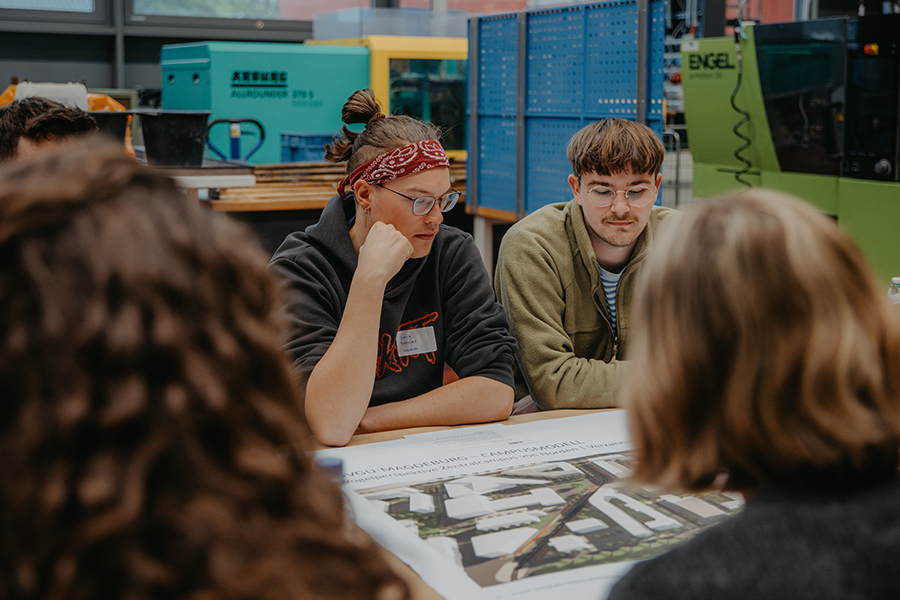 Studierende und Mitarbeitende der Uni Magdeburg tauschen sich an einem Tisch für die Gestaltung des Campus aus (c) Anna Friese Uni Magdeburg